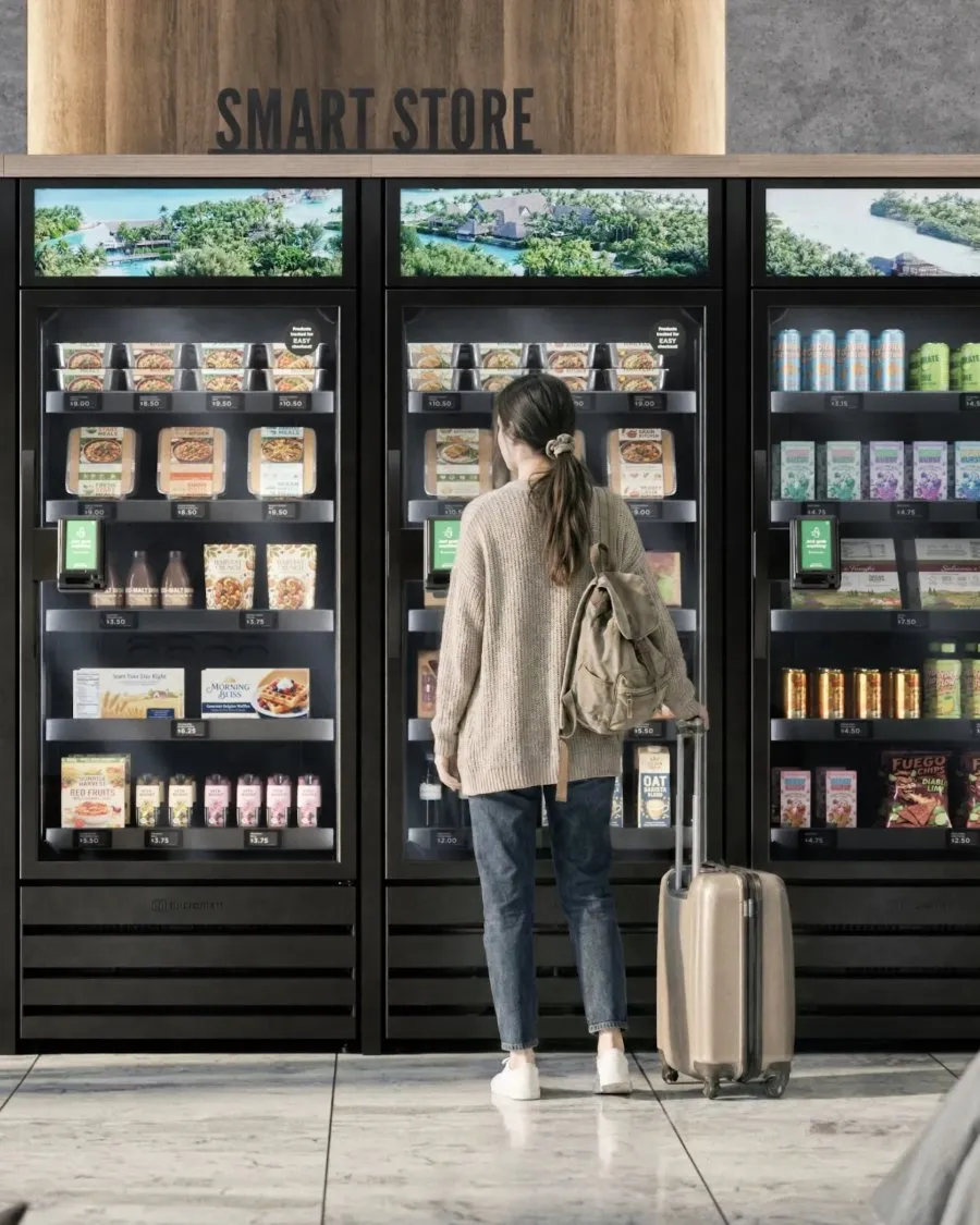 A traveler with a suitcase shopping at a multi-unit smart store